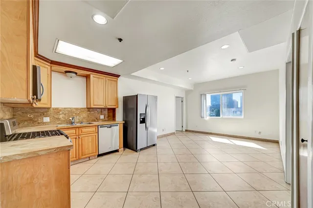 a kitchen with stainless steel appliances granite countertop a refrigerator and a stove top oven