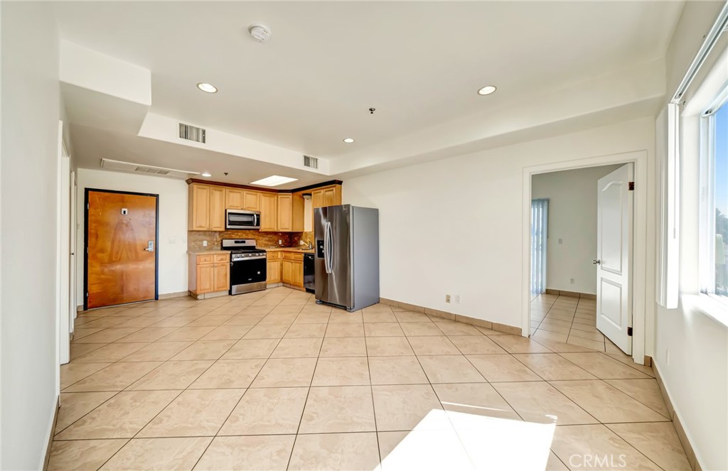 316 South New Hampshire Avenue, Unit 307 Los Angeles, CA 90020 - Photo 4 of 23 a view of a kitchen with a sink and a refrigerator