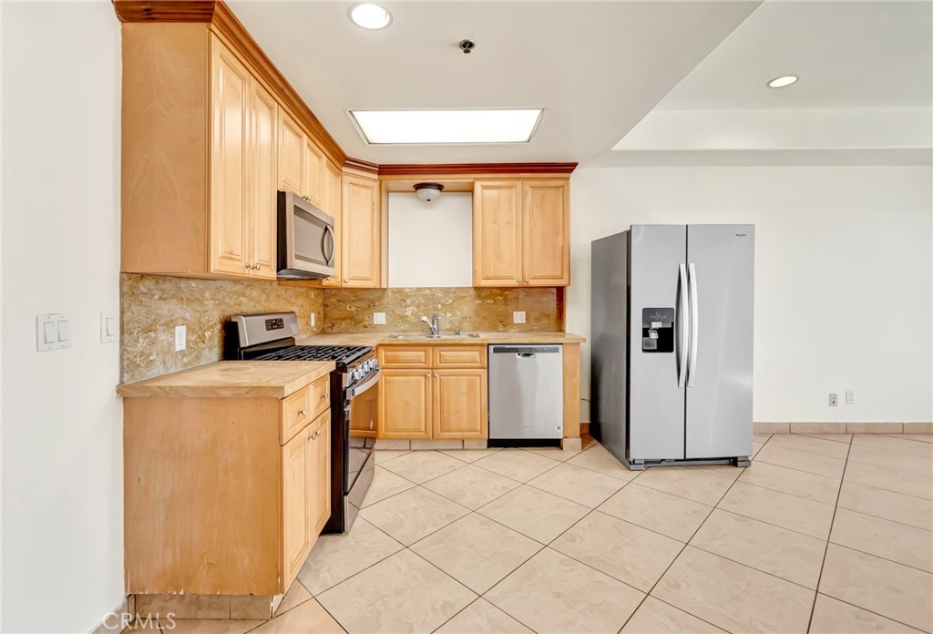 316 South New Hampshire Avenue, Unit 307 Los Angeles, CA 90020 - Photo 5 of 23 a kitchen with a refrigerator a stove top oven a sink and cabinets