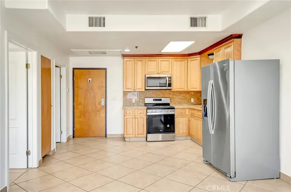 a kitchen with granite countertop a refrigerator and a stove top oven
