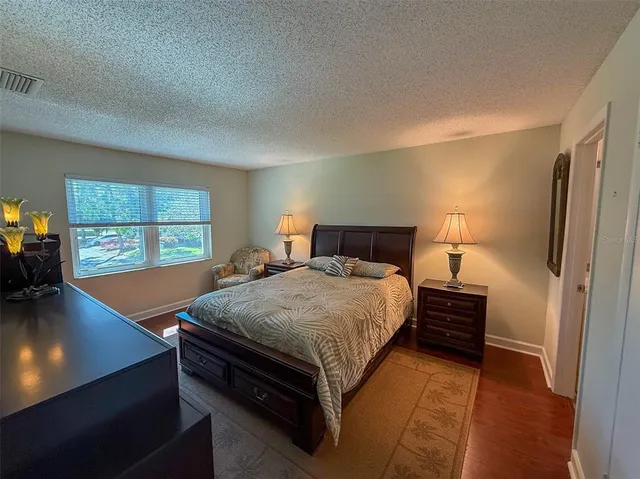 a bedroom with a bed and a flat tv screen on the dresser