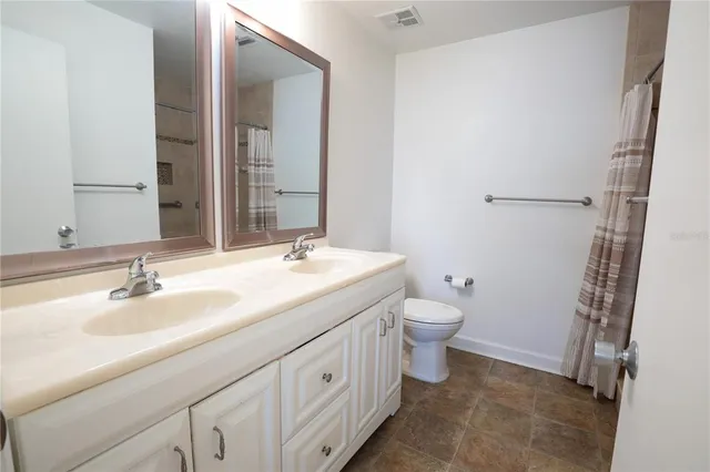 a bathroom with a double vanity sink toilet and shower