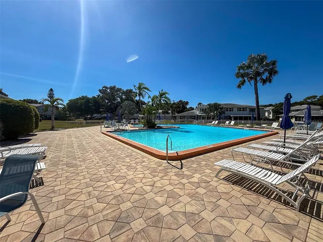 a view of a swimming pool with an outdoor seating and a yard