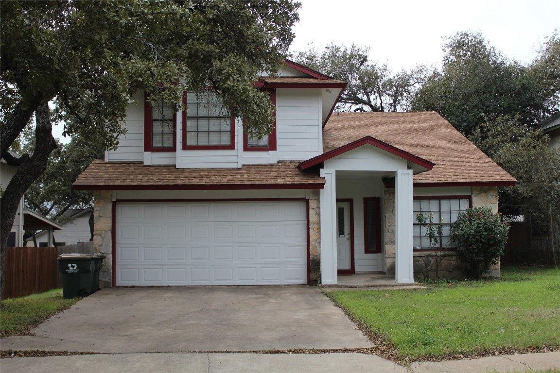 a front view of a house with a garden and trees