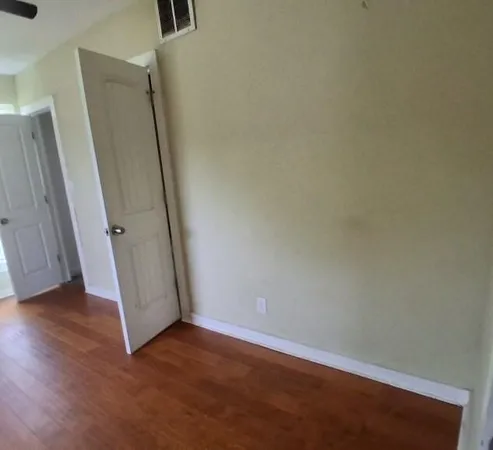 an empty room with wooden floor and a window