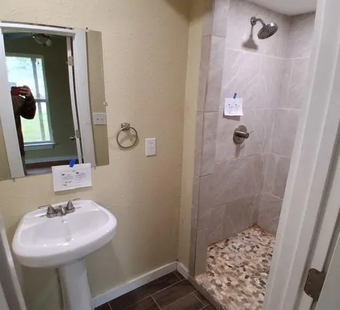 a bathroom with a sink a toilet a mirror and shower