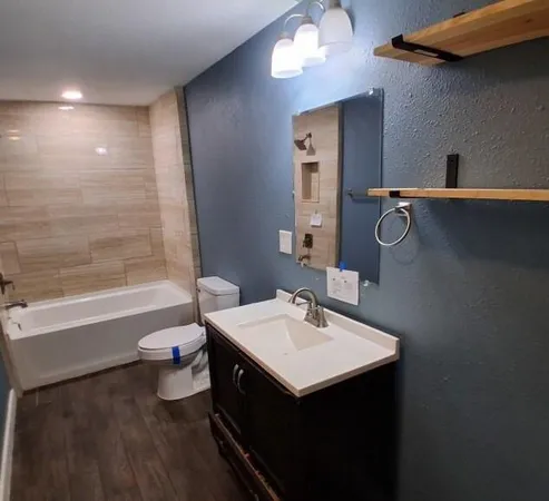 a bathroom with a sink a toilet and shower