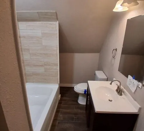 a bathroom with a sink a toilet and shower