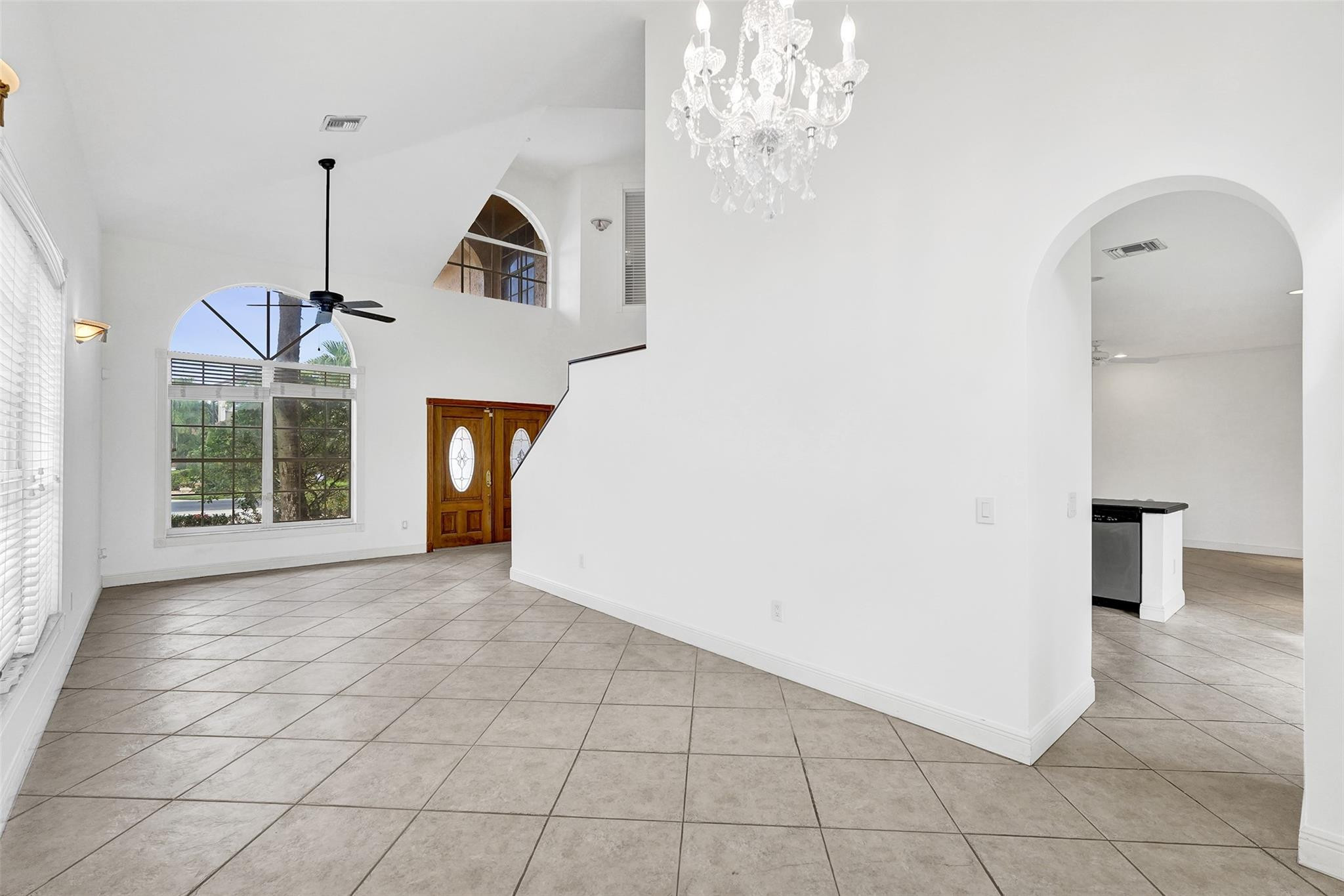 10902 Tamoron Lane Boca Raton, FL 33498 - Photo 8 of 66 a view of a room with a chandelier and windows