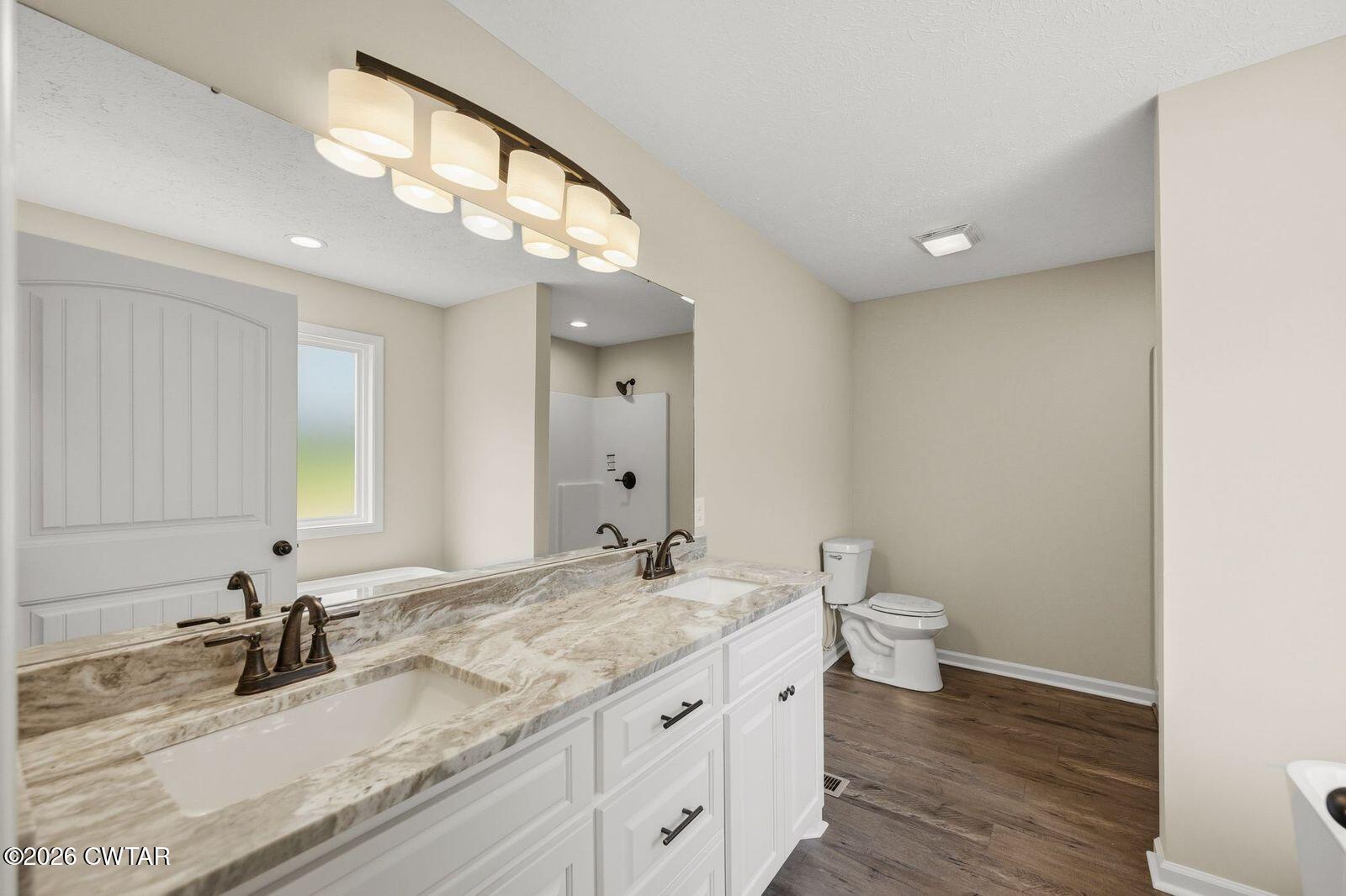 435 Old Huntingdon Road Lexington, TN 38351 - Photo 7 of 26 a bathroom with a granite countertop sink a toilet and a mirror