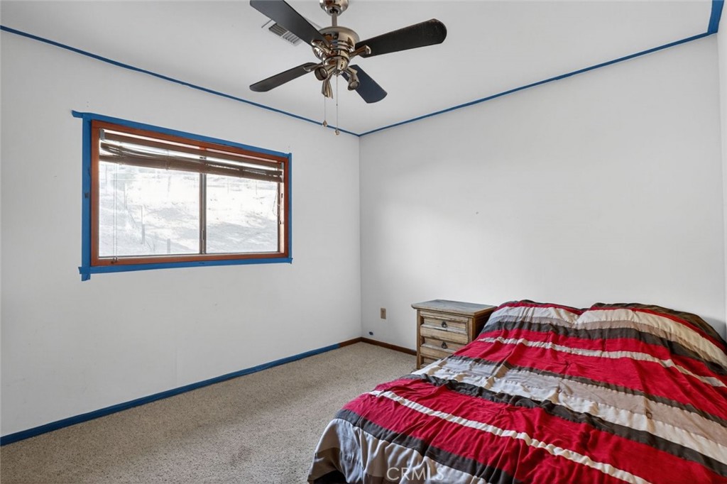 31653 Lake Meadow Road Acton, CA 93510 - Photo 26 of 32 a bedroom with a bed and a chandelier