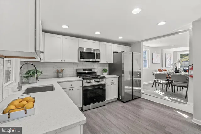 a kitchen with stainless steel appliances granite countertop a refrigerator stove microwave and sink