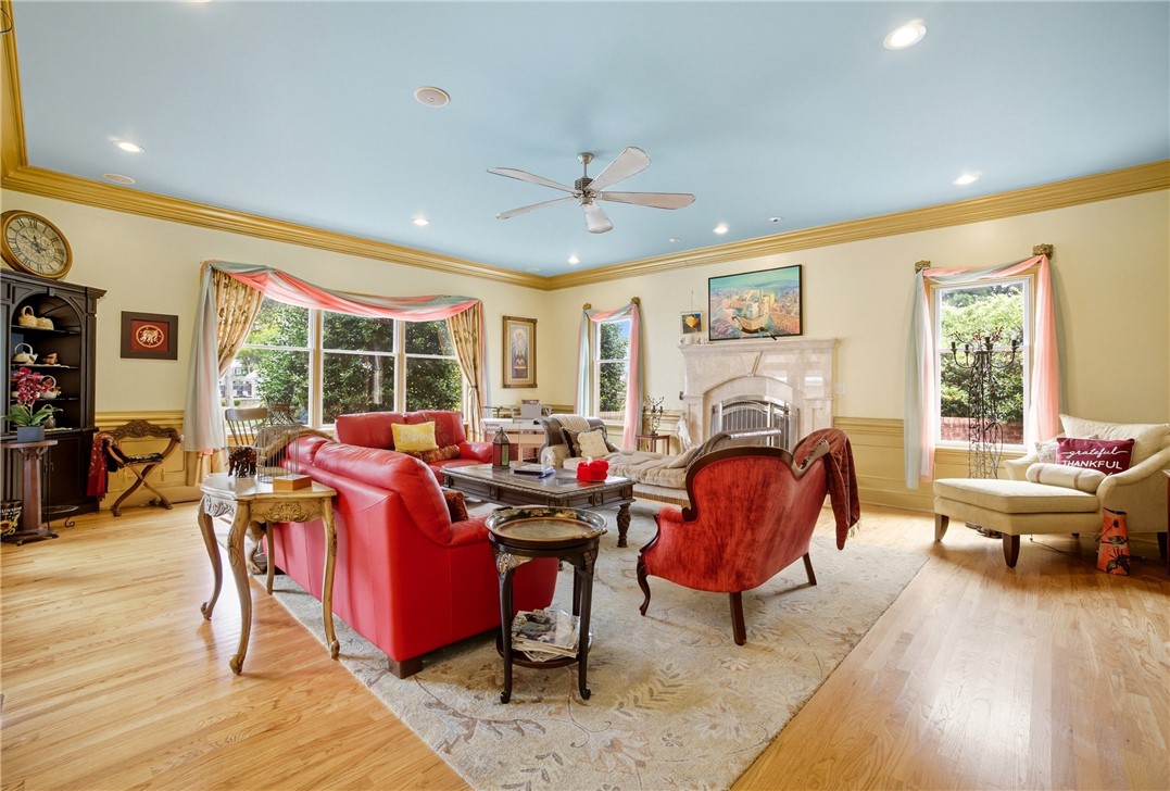 2328 Spindrift Road Virginia Beach, VA 23451 - Photo 13 of 50 Living room featuring wainscoting, ornamental molding, light wood finished floors, a fireplace, and ceiling fan