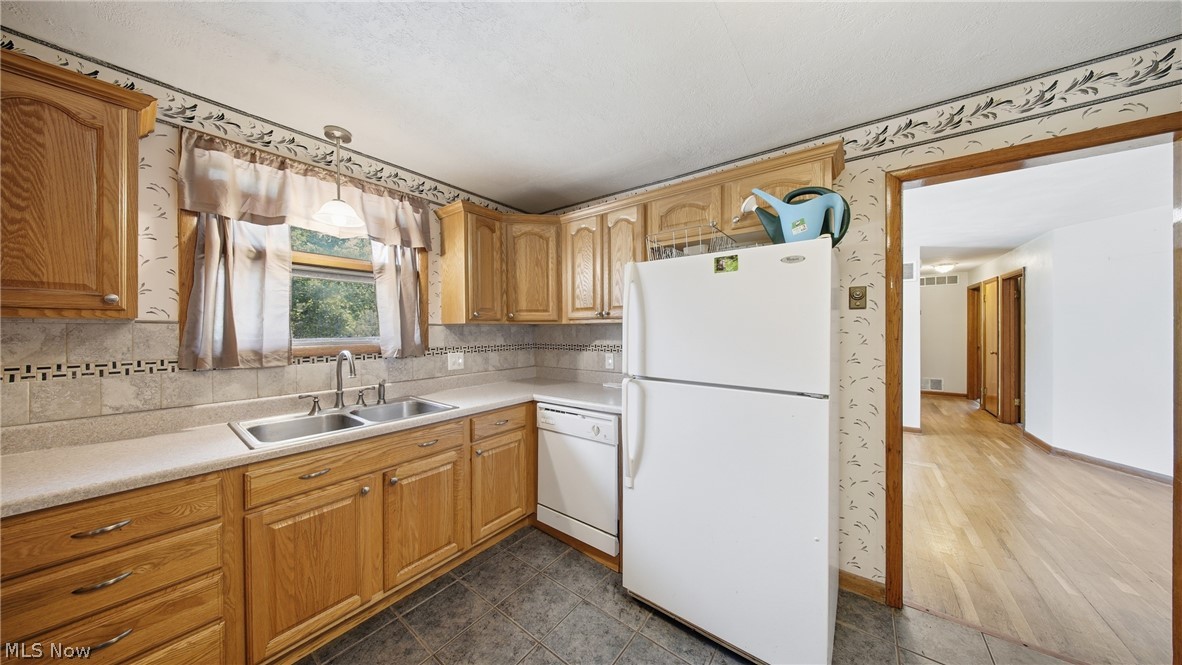 89 Dagg Road Parkersburg, WV 26101 - Photo 17 of 45 Kitchen featuring oak cabinetry, light-toned countertops, and a tile backsplash