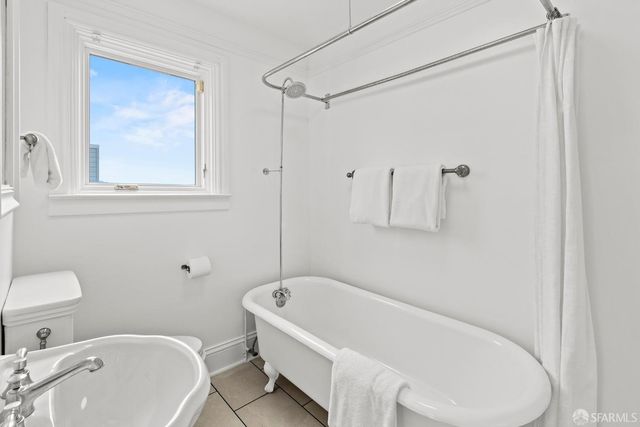 a bedroom with a bed and a lamp on dresser