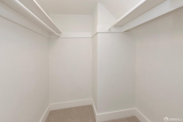 a view of an empty room with a window and cabinet with white doors