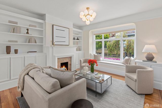 a living room with furniture a fireplace and a chandelier