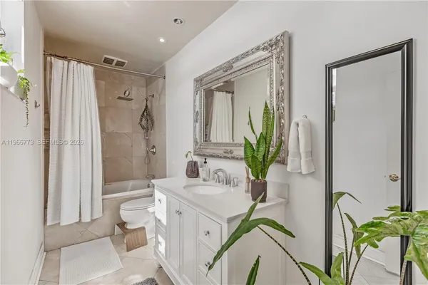 a bathroom with a granite countertop sink a toilet and shower