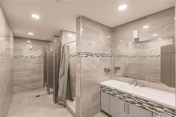 a bathroom with a granite countertop sink mirror and shower