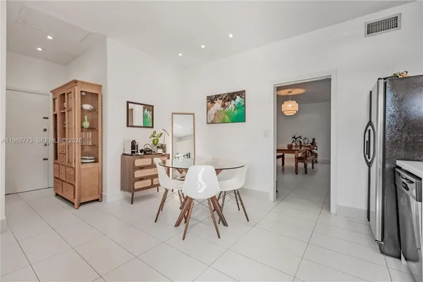 a living room with furniture a refrigerator and a table
