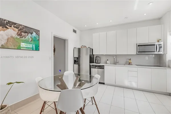 a kitchen with stainless steel appliances granite countertop a refrigerator and microwave