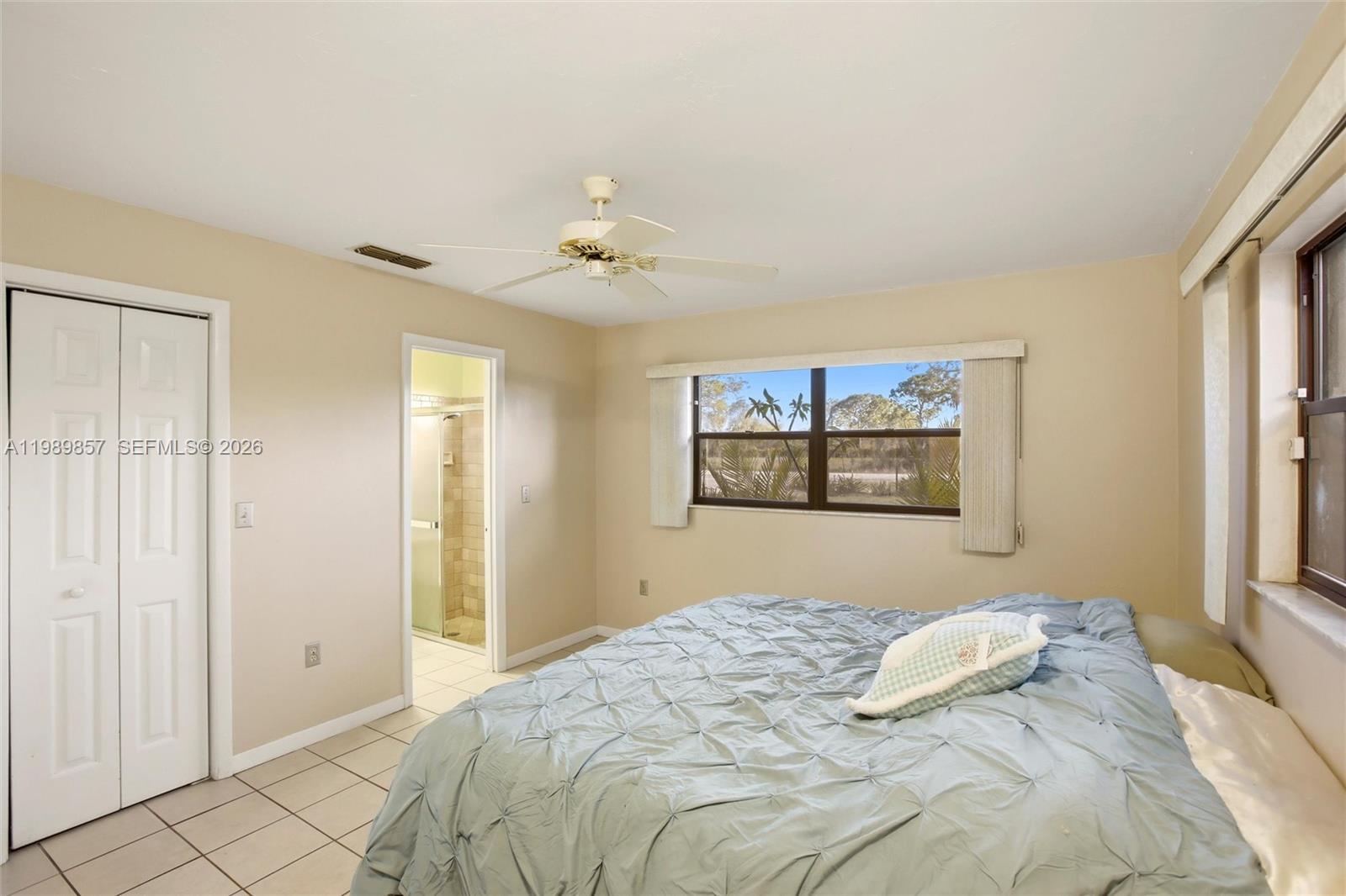 49 Williams Road Lake Placid, FL 33852 - Photo 17 of 61 a bedroom with a large bed and a chandelier
