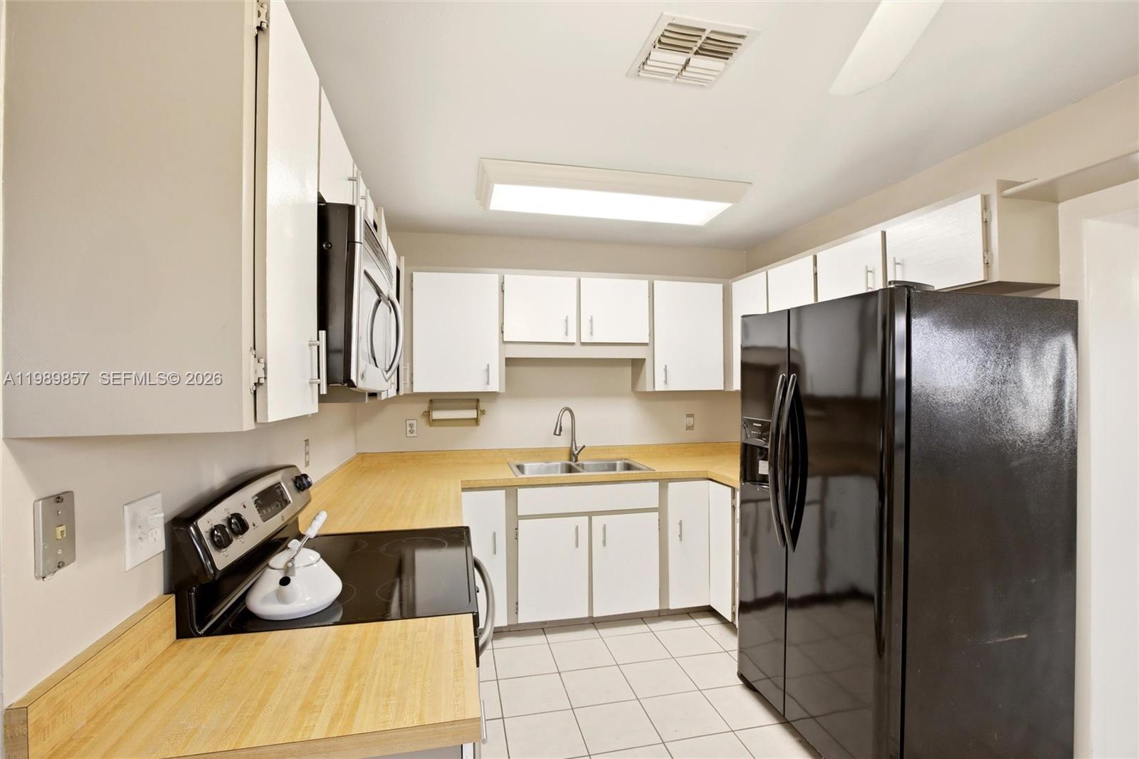 49 Williams Road Lake Placid, FL 33852 - Photo 7 of 61 a kitchen with a refrigerator a sink and cabinets