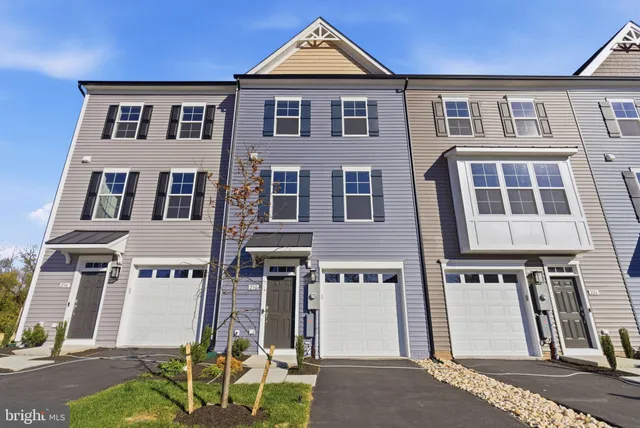 a front view of residential houses with outdoor space and parking