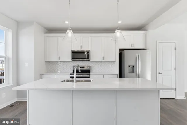 a kitchen with kitchen island white cabinets and stainless steel appliances