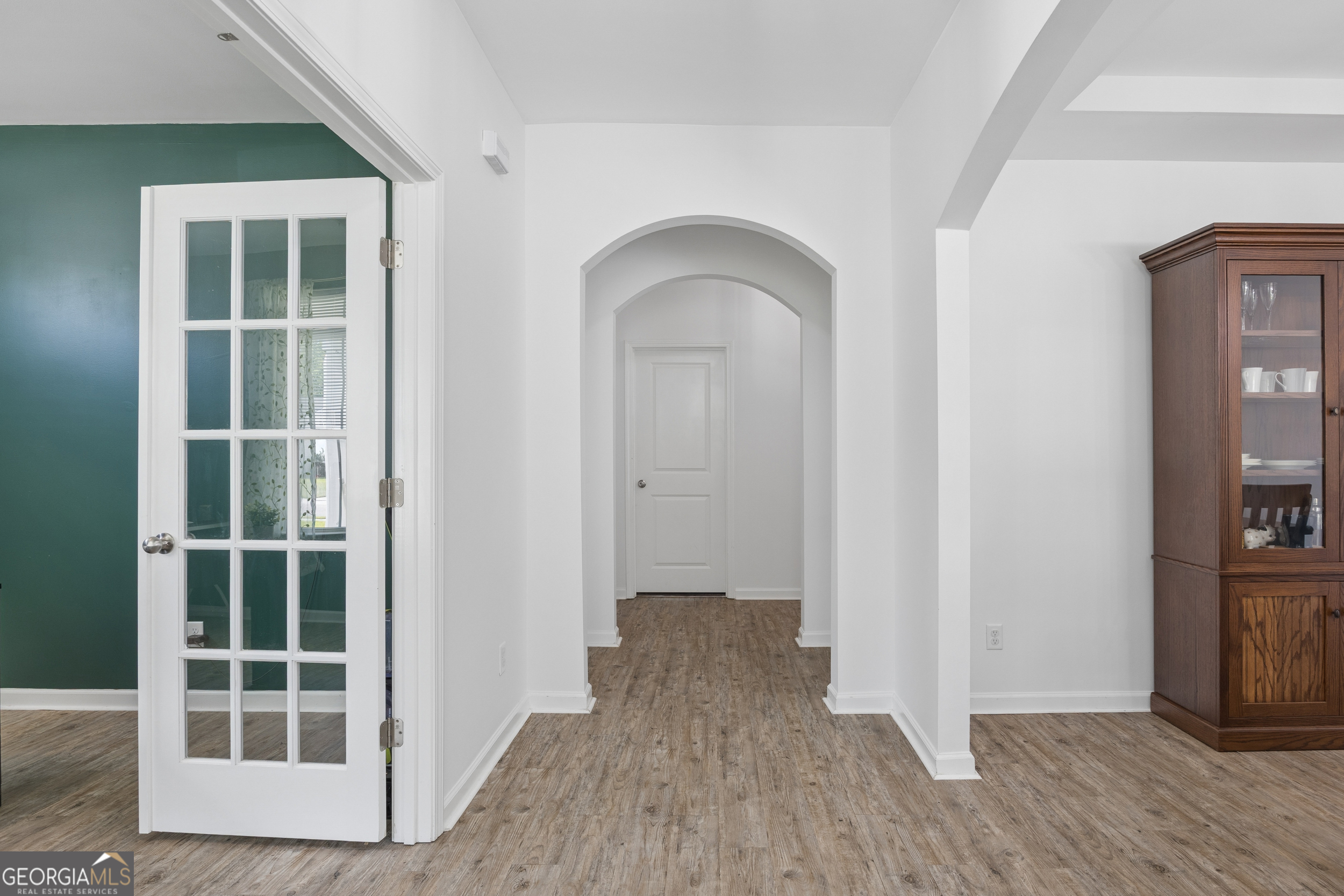 369 Waybridge Way Richmond Hill, GA 31324 - Photo 6 of 40 an empty room with wooden floor and a window