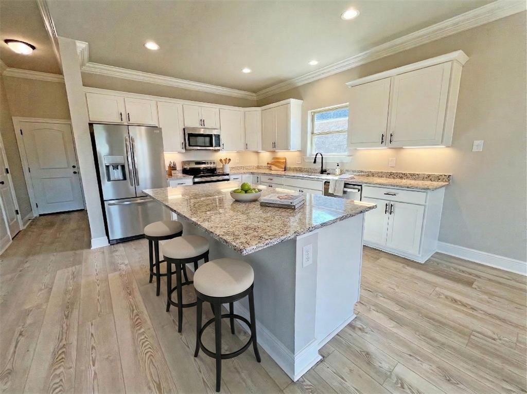 369 Hummingbird Lane Princeton, LA 71067 - Photo 7 of 22 a kitchen with kitchen island a counter top space a sink appliances and cabinets
