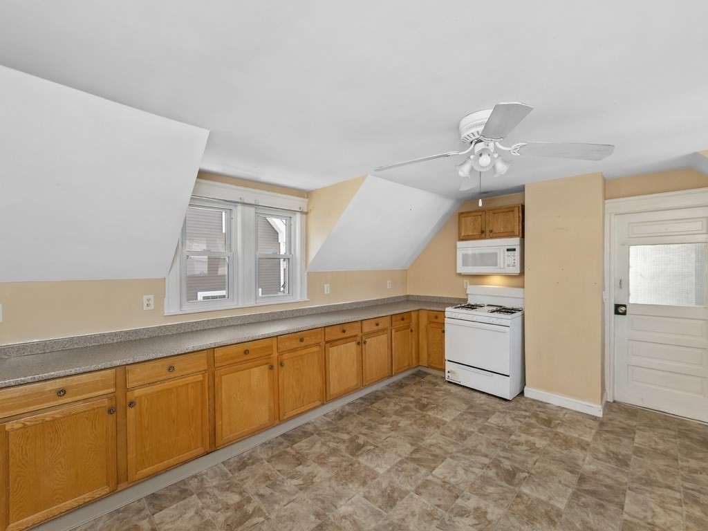 a large white kitchen with a sink a stove and cabinets