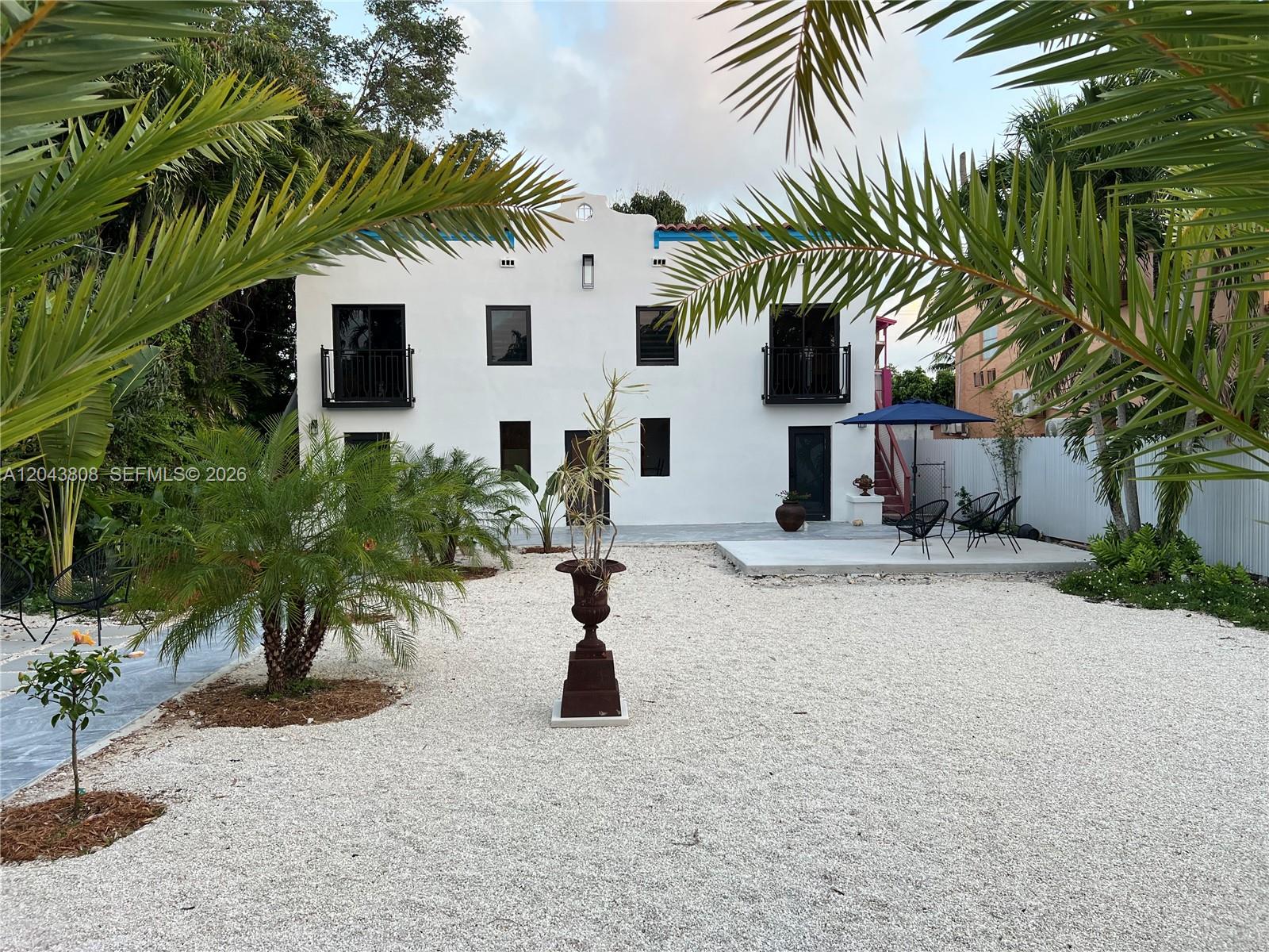 a view of a white house with a tree