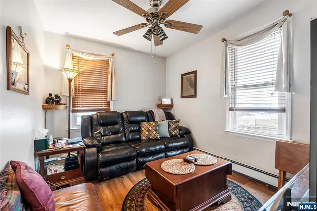 a living room with furniture a flat screen tv and a window