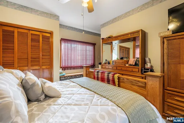 a bedroom with a bed and a large window