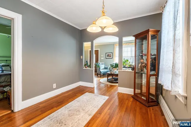 a view of a dining room with furniture a chandelier and wooden floor