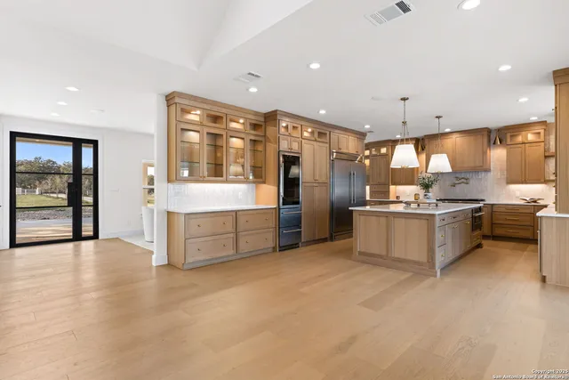 a kitchen with a stove a sink a refrigerator and chairs