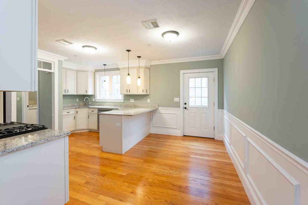 51 Branch Street, Unit 2 Quincy, MA 02169 - Photo 11 of 37 a large kitchen with cabinets and wooden floor