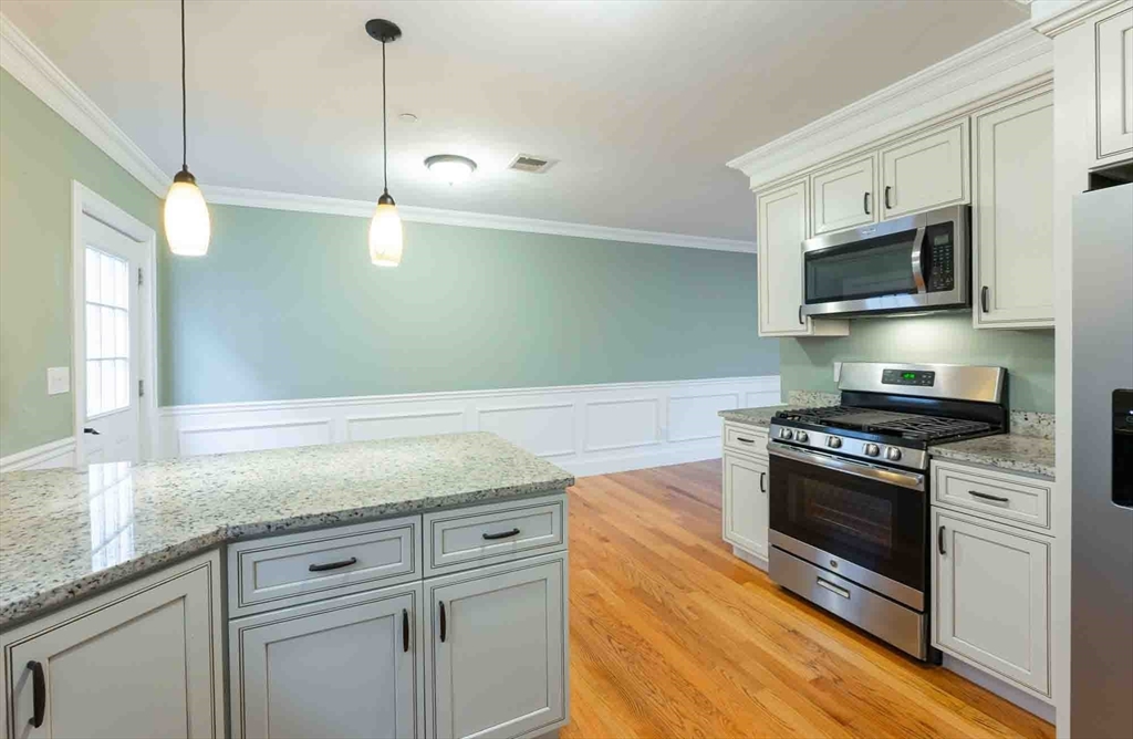 51 Branch Street, Unit 2 Quincy, MA 02169 - Photo 12 of 37 a kitchen with stainless steel appliances granite countertop a sink a stove and microwave