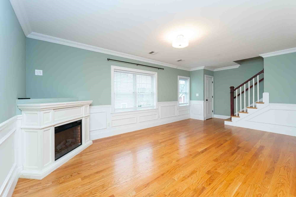 51 Branch Street, Unit 2 Quincy, MA 02169 - Photo 16 of 37 a view of empty room with wooden floor and fireplace