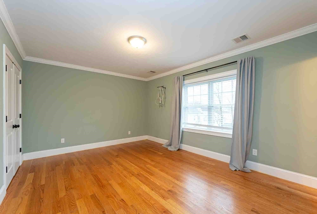 51 Branch Street, Unit 2 Quincy, MA 02169 - Photo 24 of 37 an empty room with wooden floor and windows
