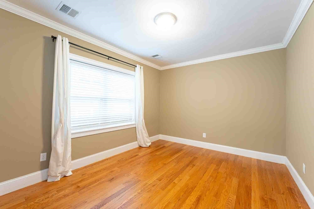 51 Branch Street, Unit 2 Quincy, MA 02169 - Photo 28 of 37 a view of an empty room with wooden floor and a window