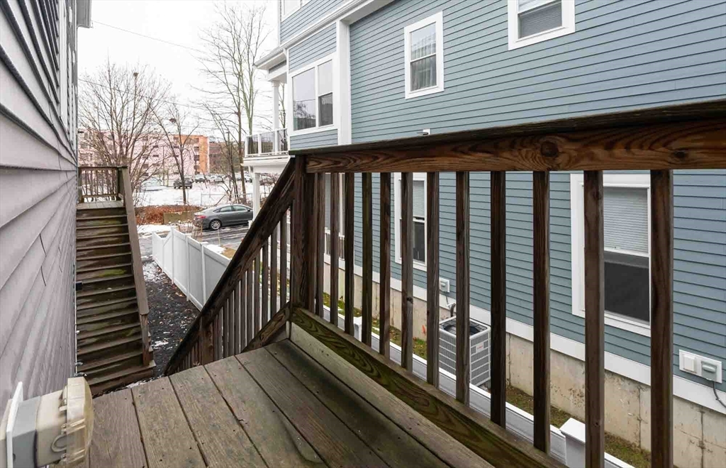 51 Branch Street, Unit 2 Quincy, MA 02169 - Photo 34 of 37 a view of a balcony with wooden floor and fence and a floor to ceiling window