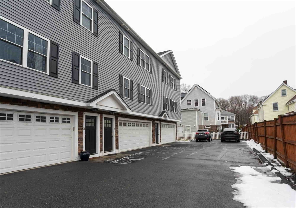 51 Branch Street, Unit 2 Quincy, MA 02169 - Photo 4 of 37 a car parked in front of a white house