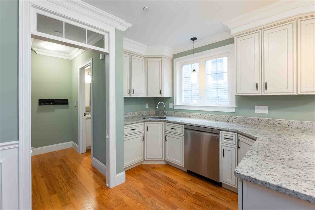 51 Branch Street, Unit 2 Quincy, MA 02169 - Photo 10 of 37 a kitchen with granite countertop a sink cabinets and wooden floor