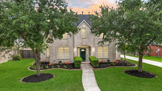 a front view of a house with a yard and trees