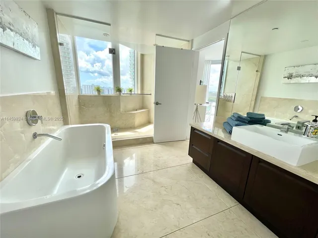 a bathroom with a bathtub sink and mirror