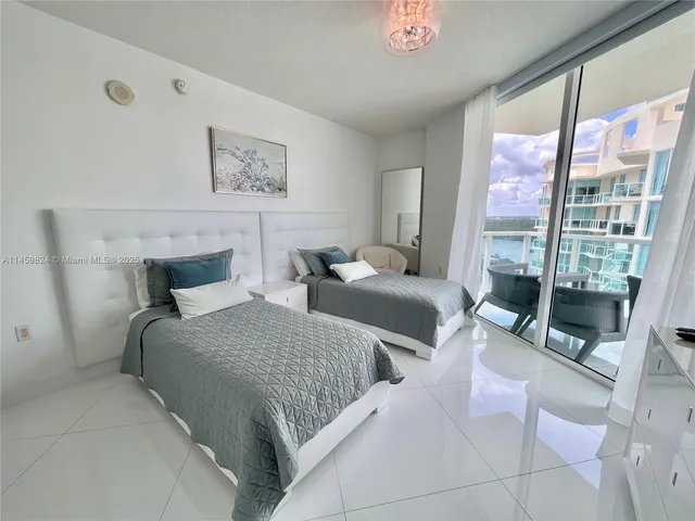 a bedroom with two large bed and a large window