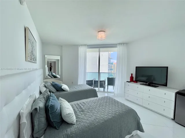 a bedroom with furniture and a flat screen tv