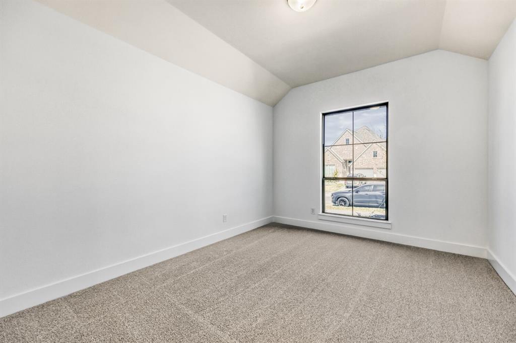 147 Derrett Lane Rhome, TX 76078 - Photo 11 of 28 Empty room featuring light carpet and vaulted ceiling